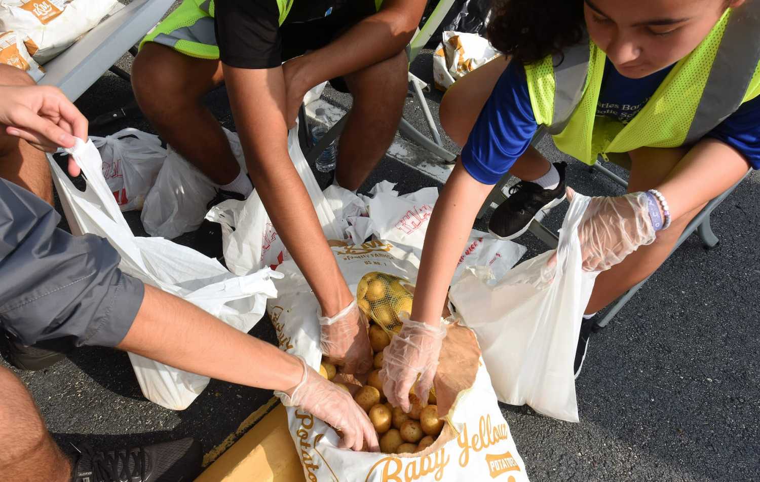 Volunteers place potatoes into small bags at a food distribution event for the needy sponsored by the Second Harvest Food Bank of Central Florida and Orange County at St. John Vianney Church in Orlando, Florida. High food and gas prices are squeezing working families, sending some to food pantries for the first time, but providers are struggling with inflation costs as demand spikes.
