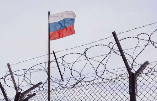 Russian flag behind a barbed wire fence