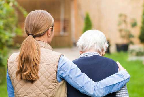 Caretaker walking with older woman