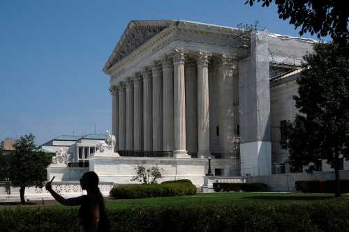 A pedestrian walks past the U.S. Supreme Court after President Joe Biden proposed sweeping changes to the nation's highest court, including term limits and a binding code of conduct for its nine justices, in Washington, U.S., July 29, 2024.