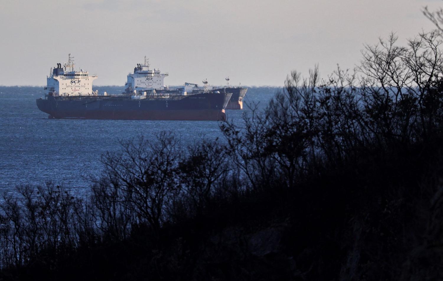 View from the shoreline of two oil tankers floating in the sea