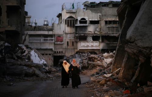 Palestinian women walk near the ruins of houses, which witnesses said were destroyed by Israeli shelling during the most recent conflict between Israel and Hamas, in the east of Gaza City December 1, 2014.