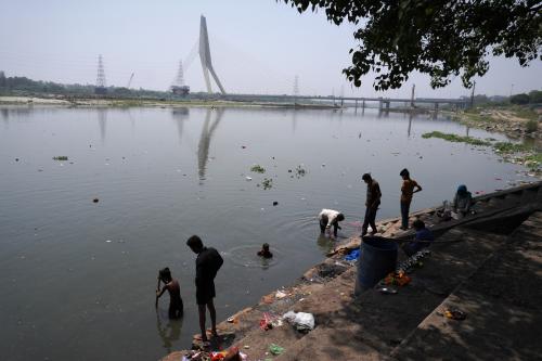 Men search for recyclable materials in the polluted waters of Yamuna river, on a hot summer day in New Delhi, India on May 14, 2022.