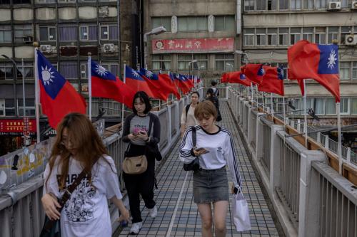 People walk on a footbridge adorned with Taiwanese flags for National Day in Taipei, Taiwan October 12, 2024.