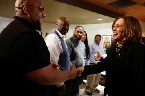 Democratic presidential nominee U.S. Vice President Kamala Harris greets a supporter as she stops at LegendErie Records and Coffee House, an Erie Black-owned small business, for a conversation with Black men, in Erie, Pennsylvania, U.S., October 14, 2024.