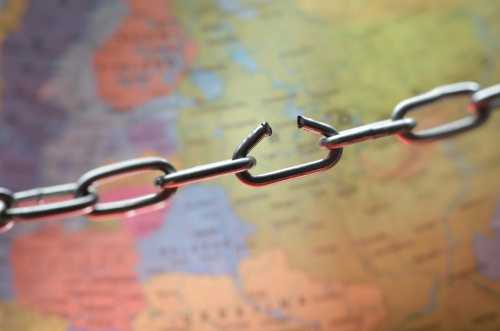 A broken chain above a map represents supply chain chaos
