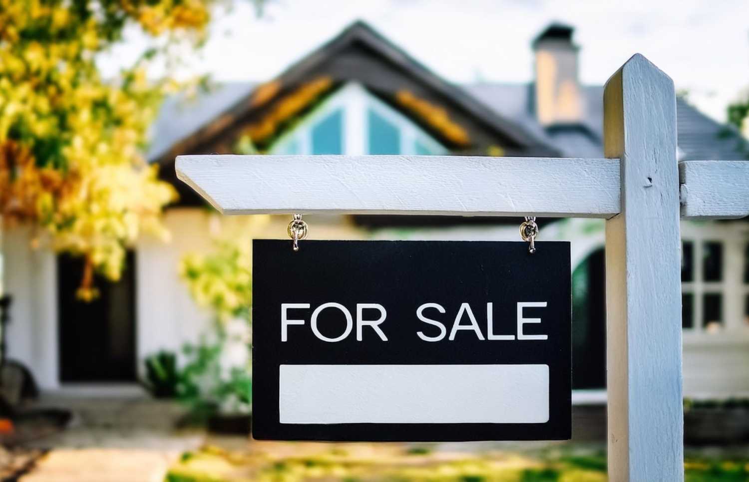 "For Sale" sign in front of a house.