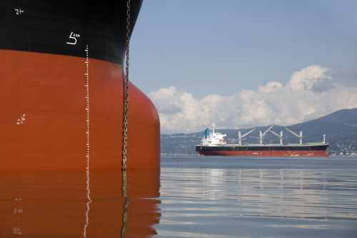 Two empty freighter ships anchored in still water