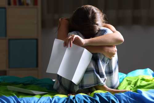 A frustrated student is shown sitting in her room after being suspended.