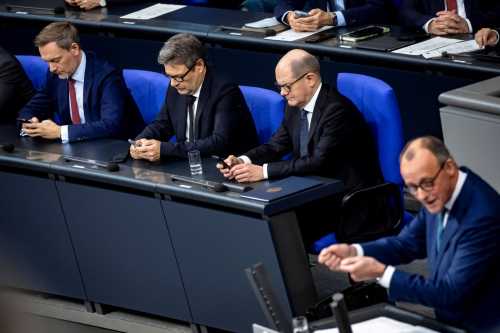 Federal Chancellor Olaf Scholz 2R , Federal Minister of Economics Robert Habeck 2L and Federal Minister of Finance Christian Lindner L look at their cell phones during the speech of CDU Chairman Friedrich Merz in the Bundestag in Berlin on December 13, 2023 plenary session in the Bundestag.