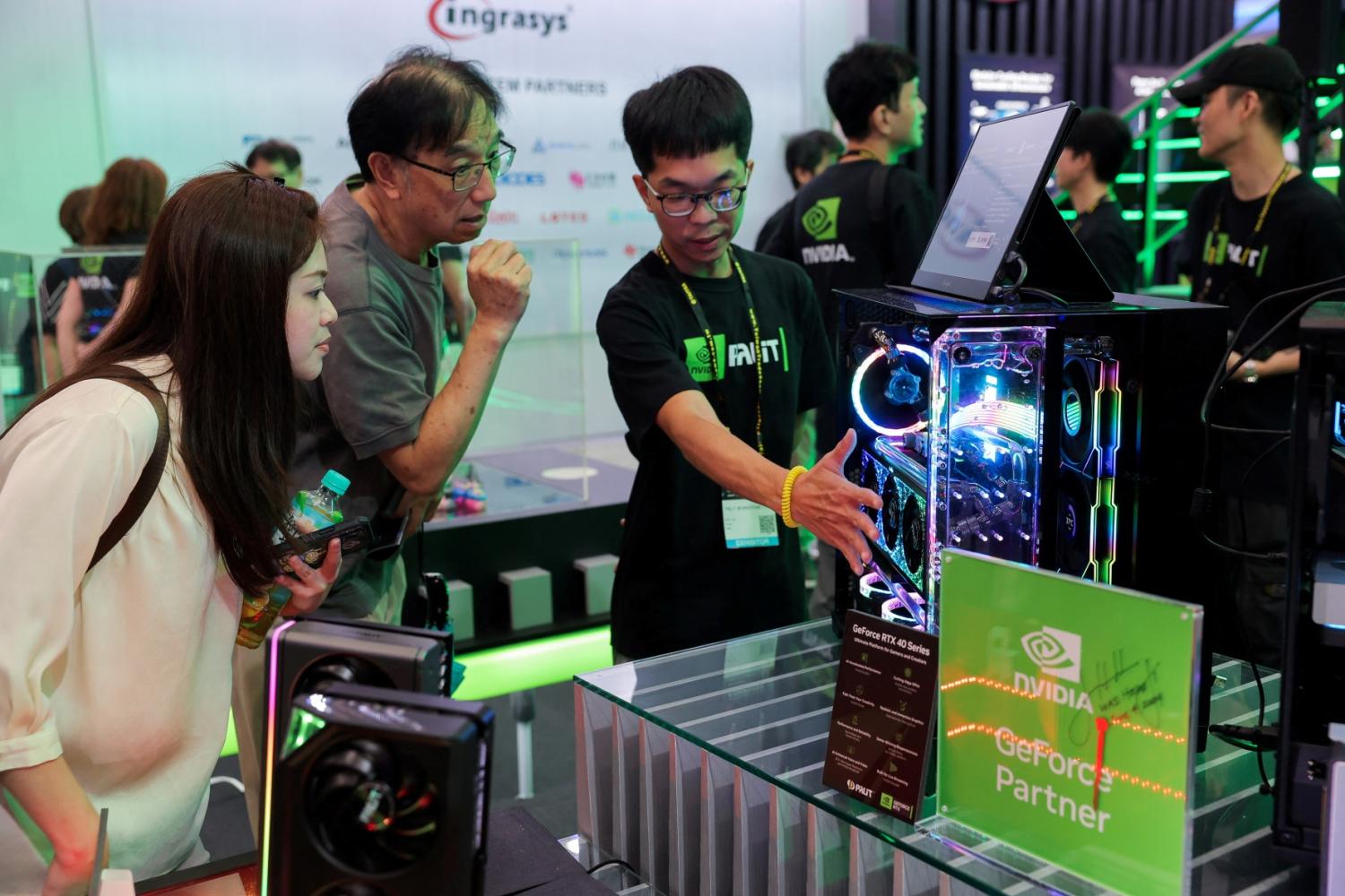 Staff introduce NVIDIA GeForce series equipment on display at Computex in Taipei, Taiwan June 5, 2024.