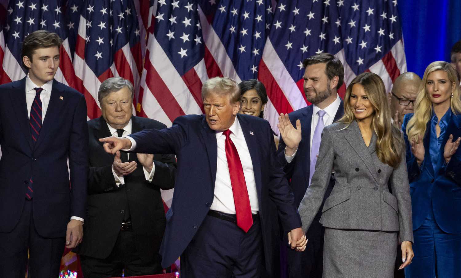 President-elect Donald Trump, flanked by his son Barron Trump, J.D. Vance, and his wife Melania Trump, points to the crowd after speaking during his election night party alongside other family and friends at the Palm Beach County Convention Center on Tuesday, November 6, 2024, in West Palm Beach, FL, USA.
