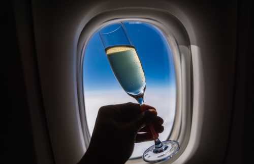 A champagne glass in front of a plane window
