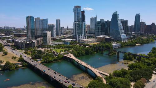 Downtown Austin TX from a drone. Aerial view of skyline in the distance with river and two bridges crossing in the forefront