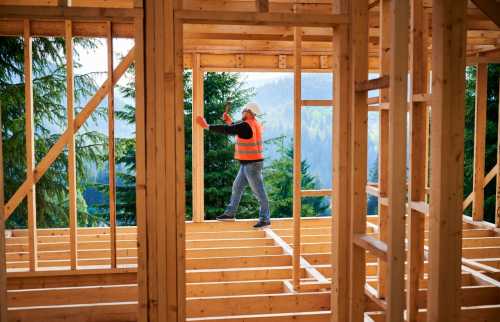 Carpenter working on frame of a house.