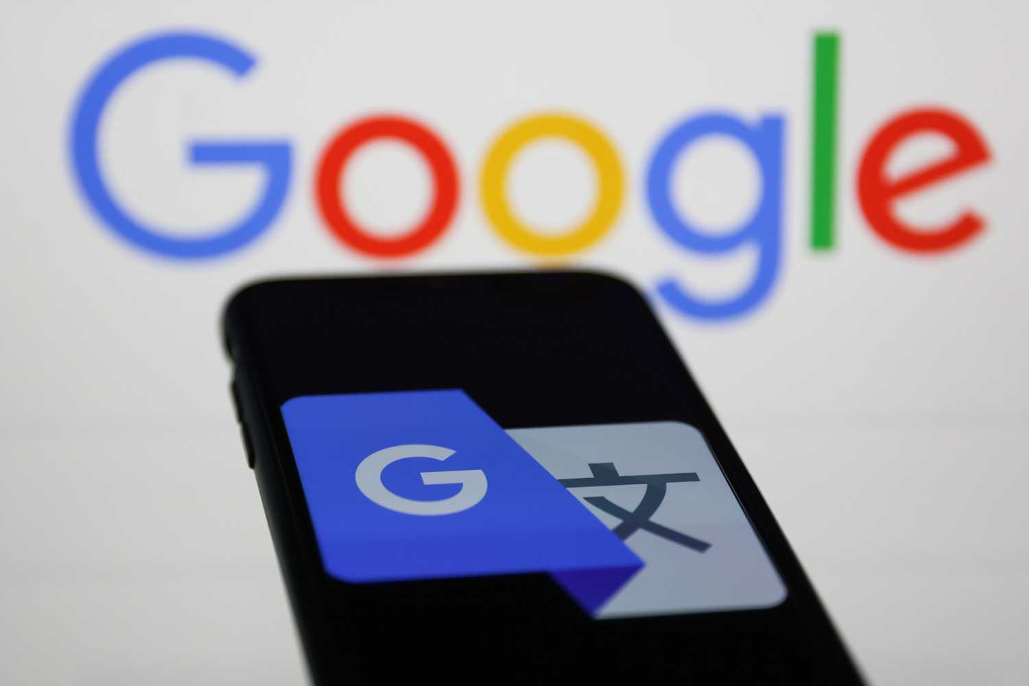 Google Translate icon displayed on a phone screen and Google logo displayed in the background are seen in this illustration photo taken on February 8, 2023.