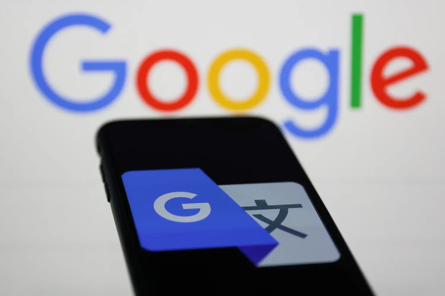 Google Translate icon displayed on a phone screen and Google logo displayed in the background are seen in this illustration photo taken on February 8, 2023.