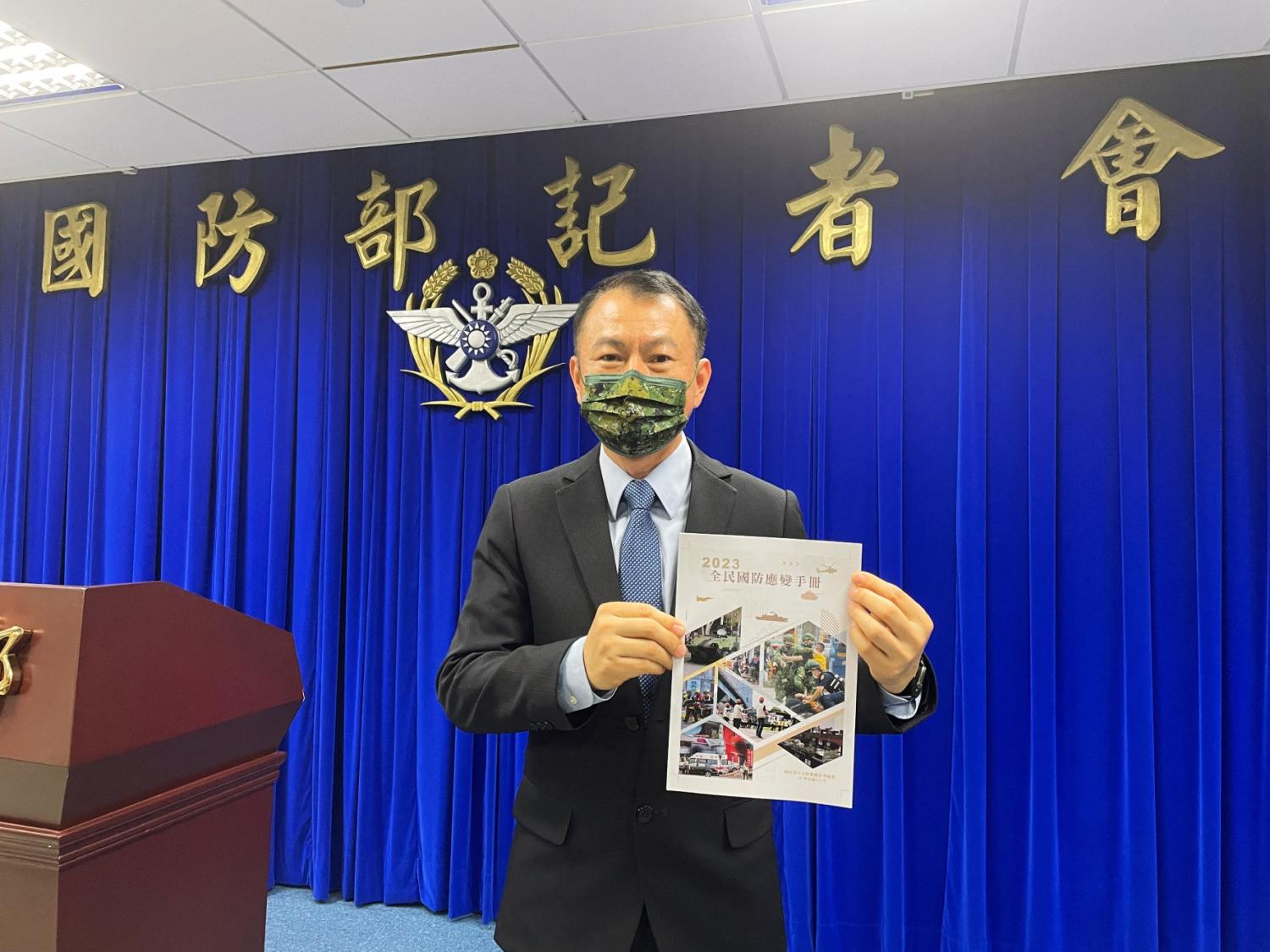 All-Out Defence Mobilization Agency Director Shen Wei-chih poses with a printout of the newest version of Civil Defence Handbook after a press conference in Taipei, Taiwan, June 13, 2023.