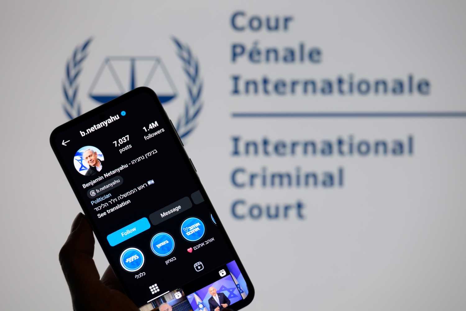 Benjamin Netanyahu's social media is displayed on a smartphone with the International Criminal Court logo visible in the background in this photo illustration in Brussels, Belgium, on November 25, 2024.
