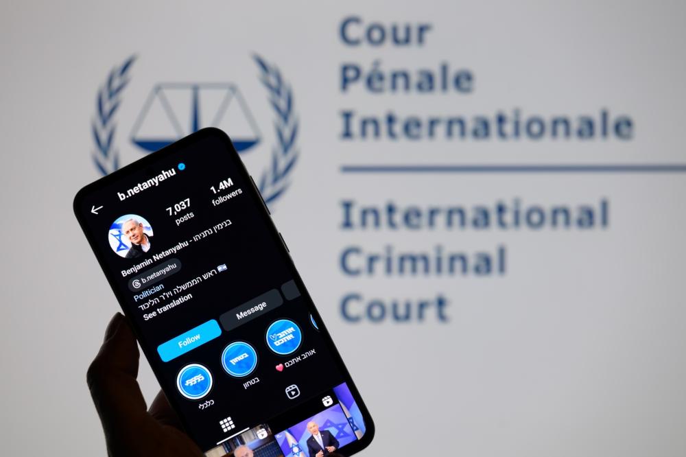 Benjamin Netanyahu's social media is displayed on a smartphone with the International Criminal Court logo visible in the background in this photo illustration in Brussels, Belgium, on November 25, 2024.
