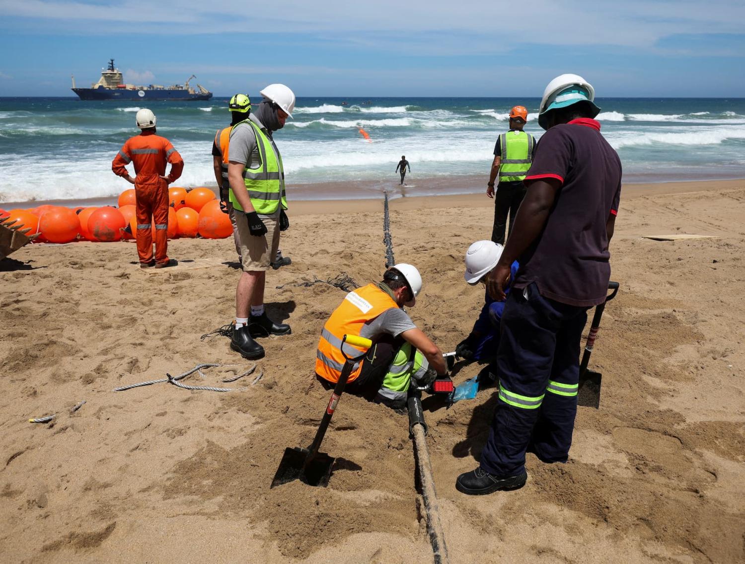 Workers install the 2Africa undersea cable on the beach in Amanzimtoti, South Africa, February 7, 2023.