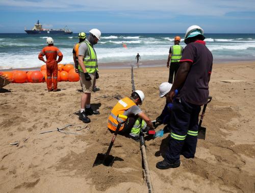 Workers install the 2Africa undersea cable on the beach in Amanzimtoti, South Africa, February 7, 2023.