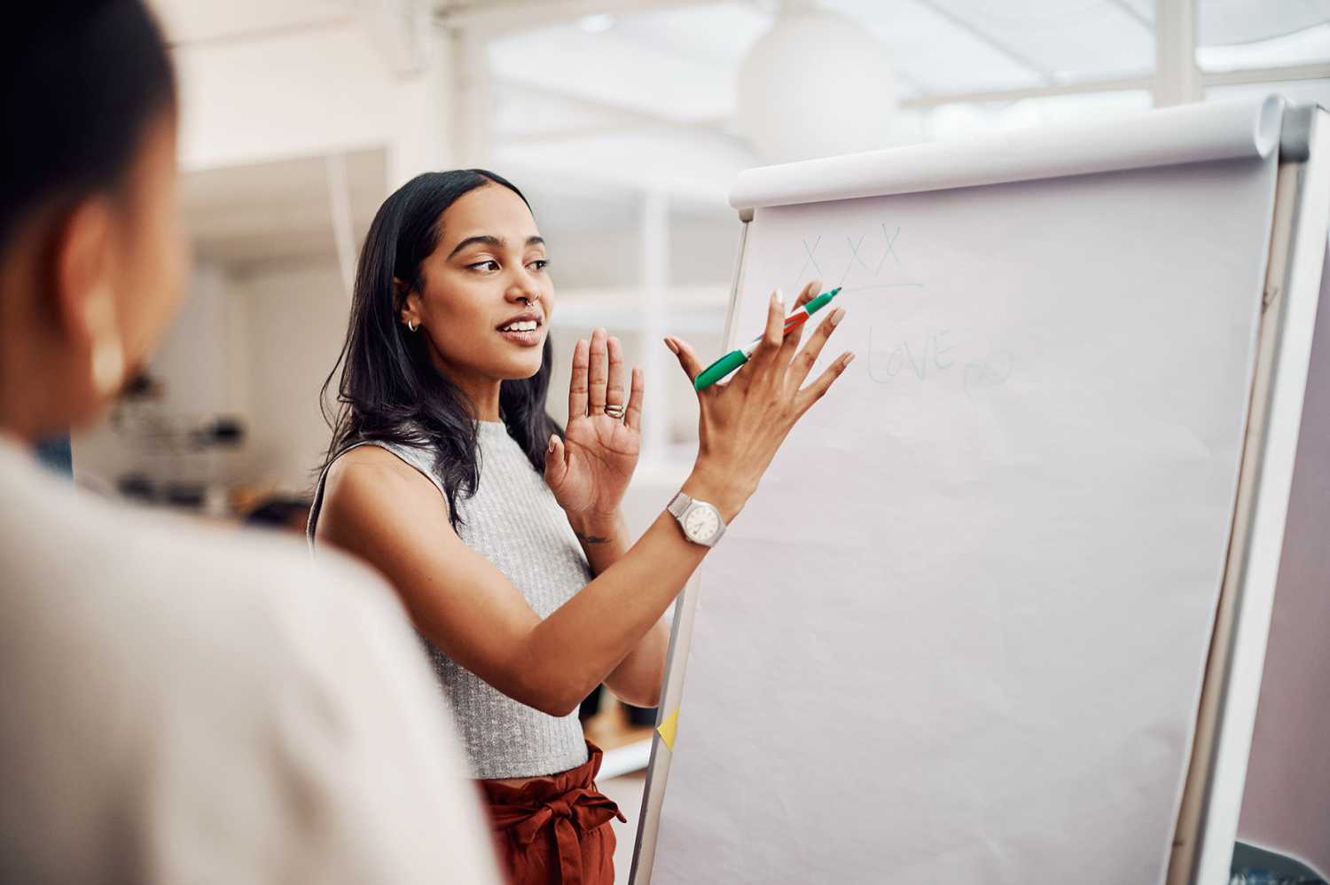 Woman, mentor and whiteboard in office for training, teaching and learning for skill or career development. People, employee and coach or leader at workshop with internship program and motivation