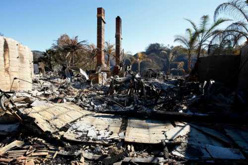A home decimated by recent wildfires sits abandoned in a Yorba Linda, California neighborhood November 18, 2008. Evacuees are returning to three areas of southern California ravaged by wildfires, some finding their homes and cars reduced to piles of smoldering, melted rubble. REUTERS/Mike Blake (UNITED STATES)