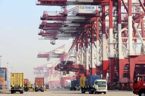 Trucks transport containers on a quay at the Port of Qingdao in Qingdao city, east Chinas Shandong province, 31 December 2013.