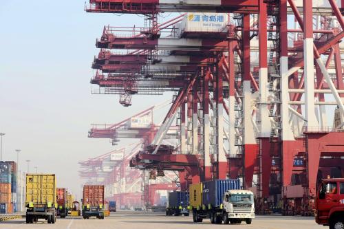 Trucks transport containers on a quay at the Port of Qingdao in Qingdao city, east Chinas Shandong province, 31 December 2013.