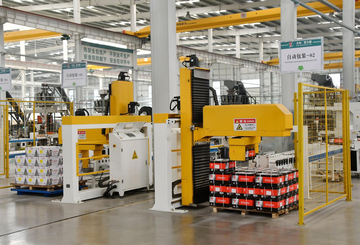Workers operating equipment in a digital intelligent workshop at a hardware manufacturing company in Handan, China.