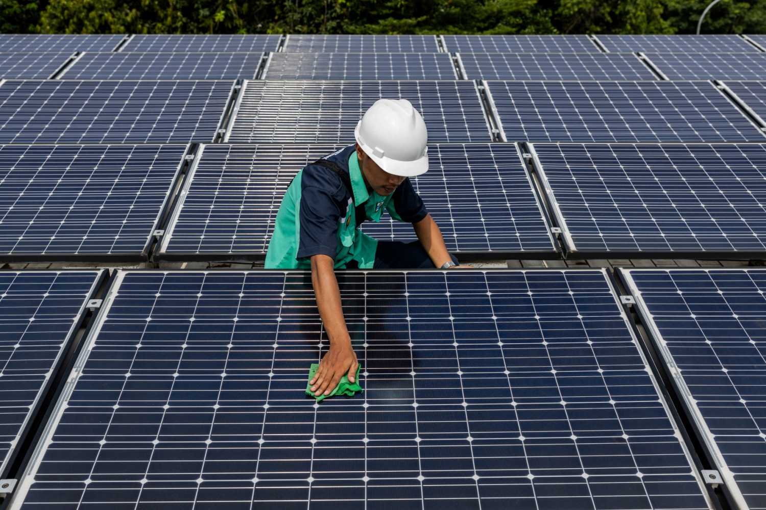 A worker is cleaning solar panels that provide partial electrical power to Istiqlal Mosque in Jakarta, Indonesia, on May 3, 2024.