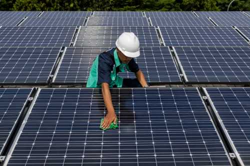 A worker is cleaning solar panels that provide partial electrical power to Istiqlal Mosque in Jakarta, Indonesia, on May 3, 2024.
