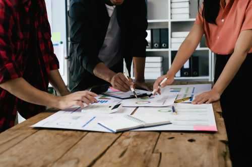 A multiethnic group of business partners gather around the office for a team meeting.