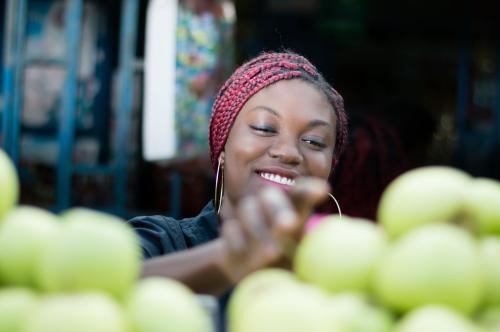 A woman reaches for an apple at the market