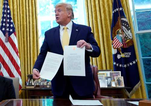 U.S. President Donald Trump holds a letter from China's President Xi Jinping during a meeting with China's Vice Premier Liu He in the Oval Office at the White House after two days of trade negotiations in Washington, U.S., October 11, 2019.