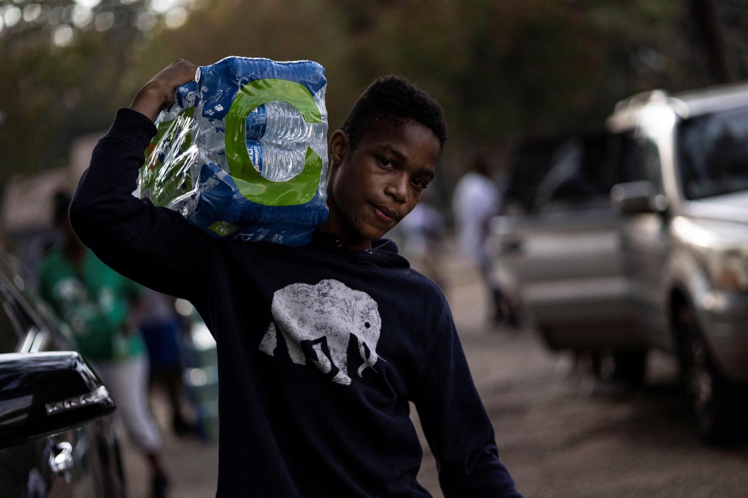 A volunteer distributes bottled water in a Mississippi town after water treatment plant pump failures left residents without reliable drinking water (Reuters/Carlos Barria)