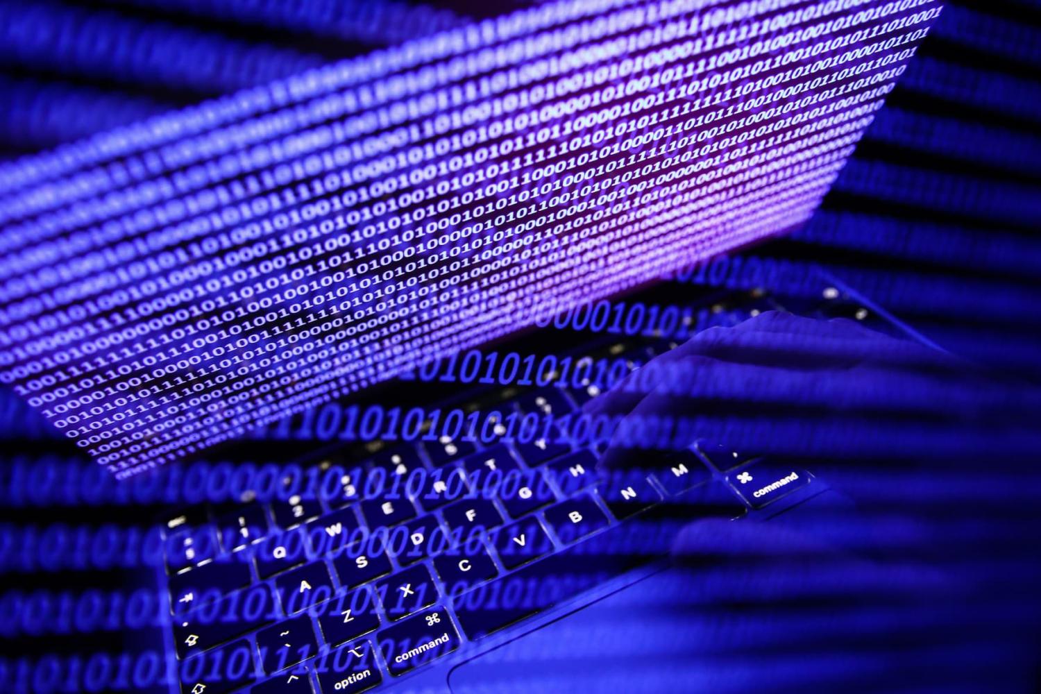 Binary code displayed on a laptop screen and binary code displayed on a screen are seen in this multiple exposure illustration photo taken on September 27, 2022.