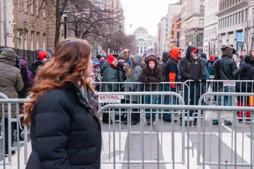 Trump supporters wait on line behind barricades to get into the Capital One Arena to watch the televised inauguration.
