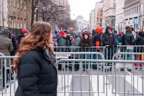 Trump supporters wait on line behind barricades to get into the Capital One Arena to watch the televised inauguration.