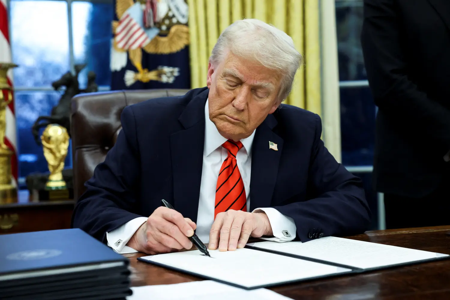 U.S. President Donald Trump signs an executive order in the Oval Office of the White House in Washington