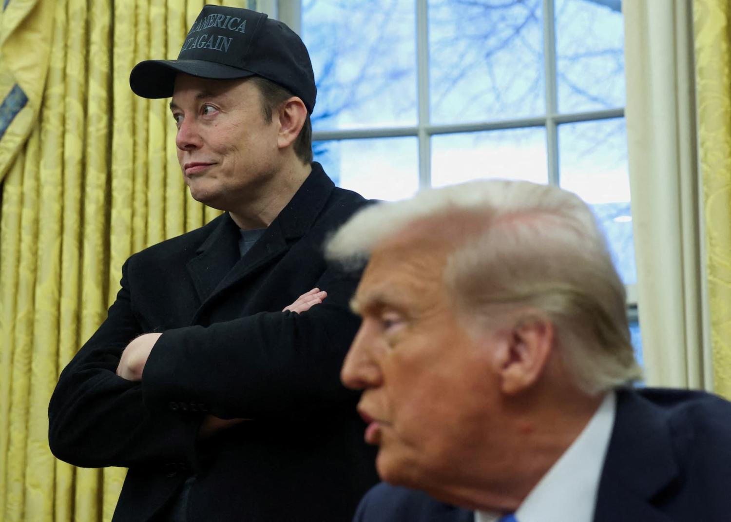 FILE PHOTO: Elon Musk listens to U.S. President Donald Trump speak in the Oval Office of the White House in Washington, D.C., U.S., February 11, 2025.
