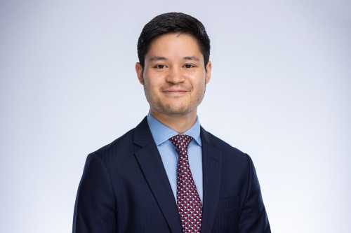 Headshot of Jam Kraprayoon with a spotted tie and a blue shirt and black suit.