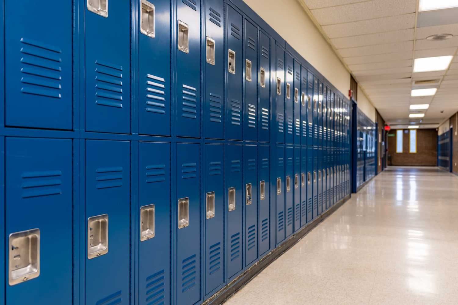 An image of an empty school hallway and blue lockers