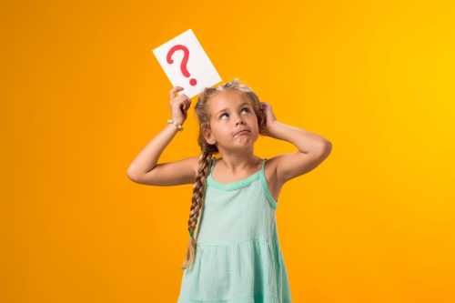 A girl is shown holding question mark card and scratching her head.