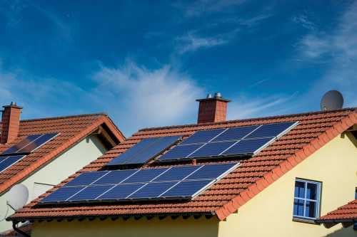 A handful of solar panels on roofs of a residential neighborhood - sustainable climate visuals
