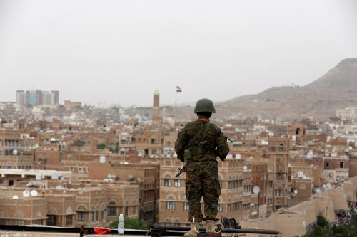 An army soldier loyal to the Houthi movement stands guard on the roof of a building overlooking the site of a demonstration against Saudi-led airstrikes in Sanaa, Yemen, July 18, 2016.
