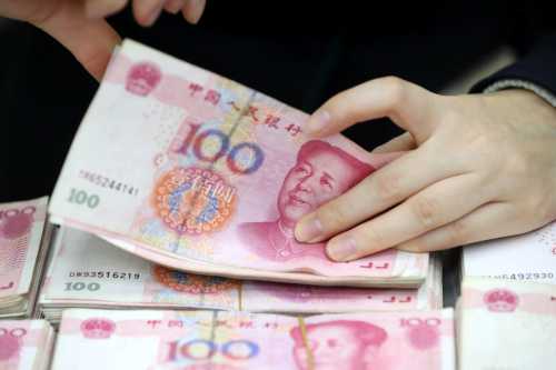 A Chinese clerk counts RMB (renminbi) yuan banknotes at a bank in Huaibei city, east China's Anhui province, 25 November 2016.
