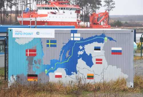 19 January 2021, Mecklenburg-Western Pomerania, Lubmin: A sign reading "Info Point Nord Stream 2 Committed Reliable Safe" hangs above a painted map at the construction site for the natural gas receiving station in the Lubmin industrial estate.