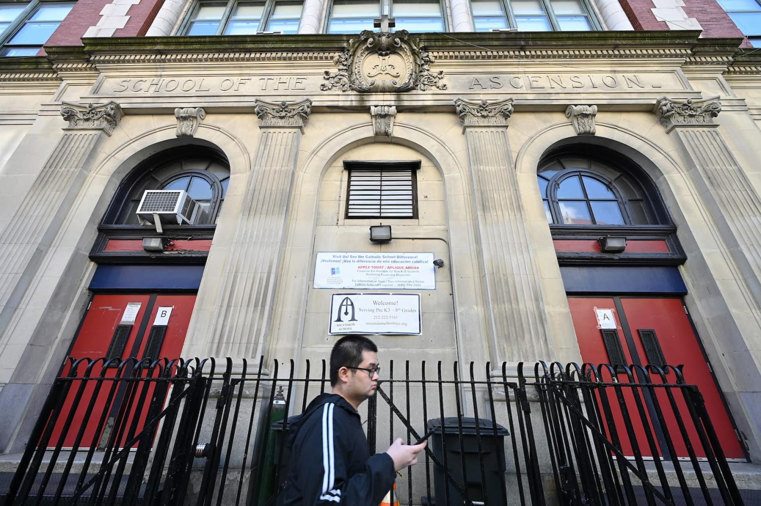 A man walks past the Ascension School, which closed at the end of the 2022-2023 academic year, in New York, NY, on February 20, 2023. Twelve Catholic schools within the Archdiocese of New York situated in Manhattan and the Bronx were selected to close or merge due to lower enrollment caused in part by COVID-19 pandemic.